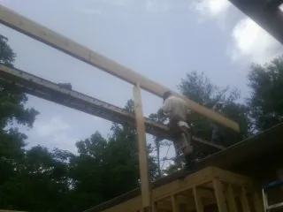 Carpenter setting a ridge beam over a new addition frame — Ice Dam Removal by Roofing Brothers in East Wenatchee